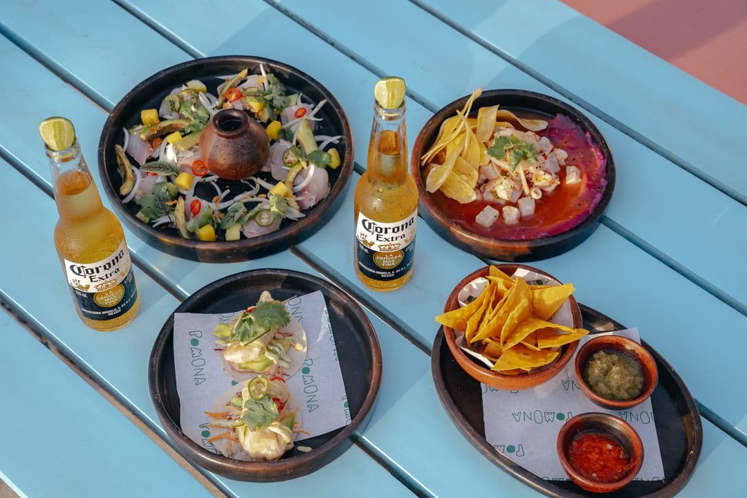 Ceviche, tacos and nachos on a blue table at Pomona